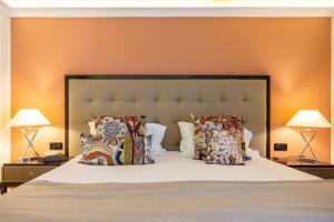 a bedroom with a bed with pillows and two lamps at Hôtel Des Gouverneurs in Bastia