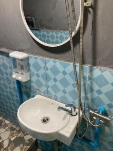 a bathroom with a sink and a mirror at โรงแรมคุ้มเดช - KoomDech Hotel in Sattahip