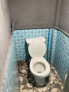 a small bathroom with a toilet in a stall at โรงแรมคุ้มเดช - KoomDech Hotel in Sattahip