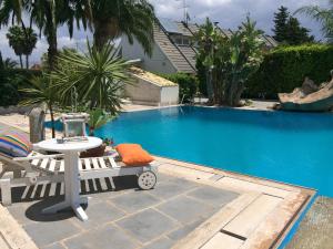 a table and a chair next to a swimming pool at Sicilia Bedda B&B in Vittoria