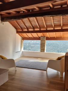 uma sala de estar com um tecto de madeira e uma grande janela em house in the medieval village em Apricale