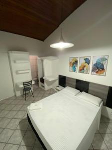 una camera con un letto bianco e una sedia di Novo Bekassin Bauru a Bauru