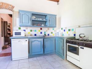 a kitchen with blue cabinets and white appliances at Magnificent Holiday Hpme in Pressac with shared pool in Pressac
