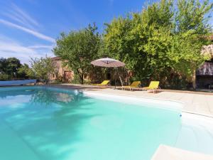 a large swimming pool with an umbrella and chairs at Magnificent Holiday Hpme in Pressac with shared pool in Pressac