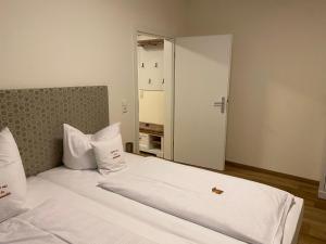 a bedroom with a large bed with white sheets at Hotel Hartl's Lindenmühle in Bad Berneck im Fichtelgebirge