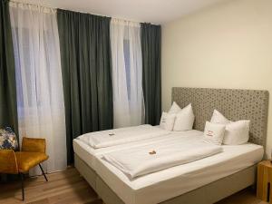 um quarto com uma cama com lençóis brancos e uma janela em Hotel Hartl's Lindenmühle em Bad Berneck im Fichtelgebirge