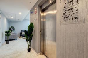 um lobby com elevador com números na parede em Hostal 37 em Estepona