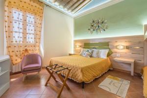 サンタ・ルーチェにあるPodere Cortesi Agriturismo Molinaccioのベッドルーム(ベッド1台、紫色の椅子付)