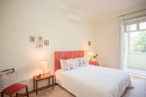 a white bedroom with a large bed and a window at Palace Museum - Espaço Palmeiras in Porto