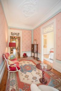 uma sala de estar com papel de parede rosa e uma mesa e cadeiras em Palace Museum - Espaço Palmeiras em Porto