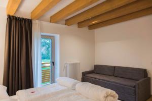 um quarto com uma cama, um sofá e uma janela em Baita Boniprati em Daone