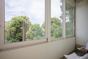 2 ventanas en una habitación con vistas a los árboles en Palace Museum - Espaço Palmeiras en Oporto