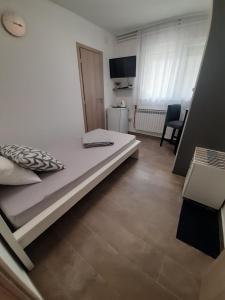 a white bed in a room with a kitchen at Happy room in Karlovac
