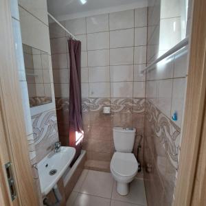 a small bathroom with a toilet and a sink at Pokoje u Teresy in Rewa