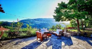 a patio with chairs and a table with a view at Il Bordone del Pellegrino in Terenzo