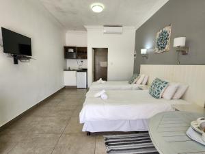 a hotel room with two beds and a tv at Hippo Lodge Apartments in St Lucia