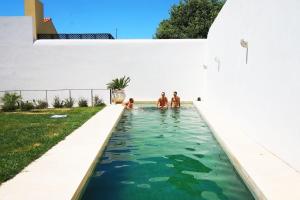 a swimming pool in a house with people in the water at The Late Birds Lisbon - Gay Urban Resort in Lisbon