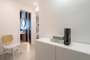 Habitación blanca con una silla y libros en una encimera en Home - Casa Favola Mia, en Monopoli