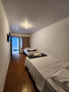 a bedroom with two beds and a balcony at Lofts Visconde in Joinville