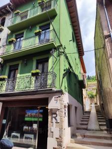un edificio verde con scale e balconi di Apartaments El Trèvol a Camprodon