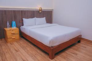 Bett mit einem Kopfteil aus Holz und einem Nachttisch in der Unterkunft pokhara in Pokhara