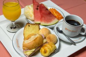 a tray with a plate of food and a cup of coffee at Hotel Metropolitano in Coronel Fabriciano