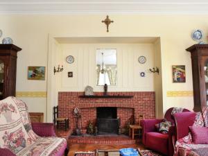 - un salon avec une cheminée en briques et des chaises violettes dans l'établissement Comfortable Mansion in Doomkerke near Forest, à Ruiselede
