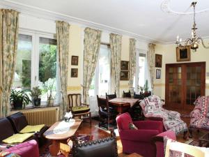 a living room with purple chairs and a table at Comfortable Mansion in Doomkerke near Forest in Ruiselede