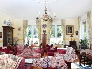 a living room filled with lots of furniture and windows at Comfortable Mansion in Doomkerke near Forest in Ruiselede