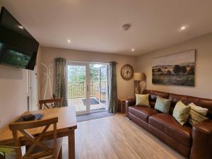 a living room with a couch and a table at Chestnut Lodge with Hot Tub in Cupar