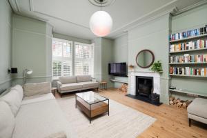 sala de estar con sofá y chimenea en Beautiful 4BR Home in Vibrant Haringey en Londres