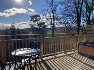 a table and chairs on a deck with a view at Chestnut Lodge with Hot Tub in Cupar