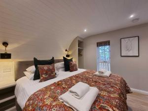 a bedroom with a large bed with towels on it at Chestnut Lodge with Hot Tub in Cupar