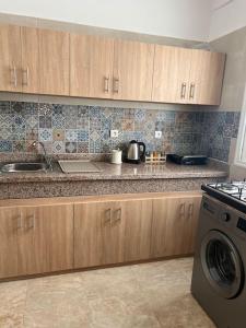 a kitchen with a sink and a washing machine at Emplacement idéal : Appartement lumineux El Jadida in El Jadida