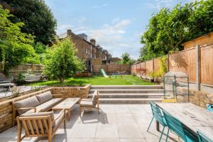 un patio con tavoli e sedie e un parco giochi di Beautiful 4BR Home in Vibrant Haringey a Londra