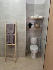 a bathroom with a toilet and towels on shelves at Emplacement idéal : Appartement lumineux El Jadida in El Jadida