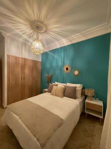 a bedroom with a large bed with a blue wall at Emplacement idéal : Appartement lumineux El Jadida in El Jadida