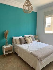 a blue bedroom with a bed and a blue wall at Emplacement idéal : Appartement lumineux El Jadida in El Jadida