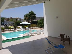 a patio with chairs and a swimming pool at Villa Limone in Castellammare del Golfo