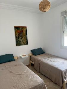 a room with two beds and a window at Emplacement idéal : Appartement lumineux El Jadida in El Jadida