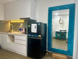 a kitchen with a blue frame around a black refrigerator at Papilio Homestay Tay Ho in Hanoi