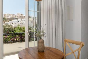 a table and a chair in a room with a window at Pension Sofi in Naxos Chora