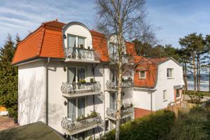 um edifício branco com um telhado laranja em Appartement-Villa Steinfurth em Binz