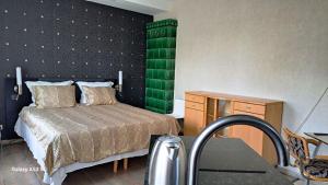 - une chambre avec un lit et un mur vert dans l'établissement KaunasInn, à Kaunas