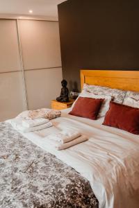 アスペイティアにあるBaioleiの白い大型ベッド(赤い枕付)、上にテディベアが備わります。