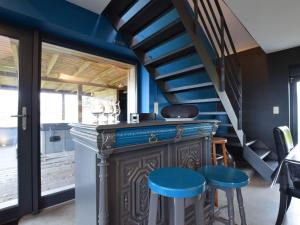 Morhet的住宿－Modern Cottage in Vaux sur S re with Sauna，一间酒吧,房间拥有蓝色的墙壁和蓝色的凳子