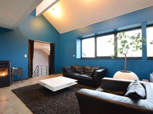 uma sala de estar com um sofá e uma mesa em Modern Cottage in Vaux sur S re with Sauna em Morhet