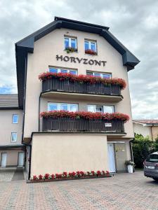 un edificio con flores a un lado. en Villa Horyzont, en Międzywodzie