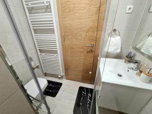een badkamer met een toilet, een wastafel en een douche bij River Walk Apartman in Sarajevo