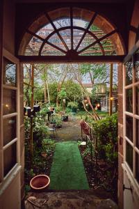 a view of a garden through an archway into a yard at Le Couvent in LʼHermenault